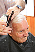 Man with dementia having his hair cut
