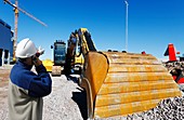 Surveyor on construction site with bulldozer