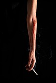 Bleeding arm holding cigarette