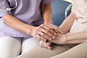 Care worker holding senior woman's hands
