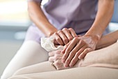 Care worker holding senior woman's hands