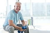 Senior man holding weights