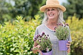 Senior woman holding pot plants