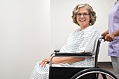 Nurse pushing female patient in wheelchair