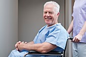 Man in hospital gown in wheelchair