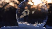 Ice crystals forming on a soap bubble