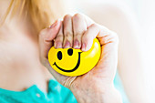 Woman kneading a smiley stress ball