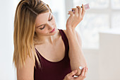 Woman applying cream on her elbow