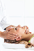 Woman's head manipulated by an osteopath
