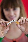 Woman snapping a cigarette in half