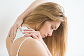 Woman applying heat patch for backache
