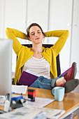 Woman relaxing and stretching arms at work