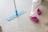 Cleaner mopping a hospital ward floor