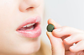 Woman taking food supplement of spirulina algae