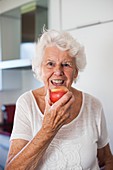 Elderly woman eating an apple
