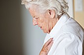 Elderly woman holding her chest
