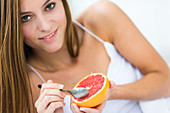 Woman eating a grapefruit