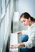 Woman adjusting radiator valve