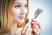 Woman smelling a bottle of thyme essential oil