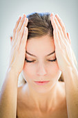 Woman giving herself a temple massage