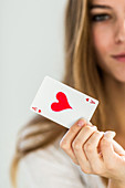 Female holding an ace of hearts