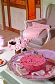 Pinkes Dessert auf rosafarbenem Teller mit Rosenblättern