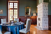 Gedeckter Tisch und Kachelofen im Château Des Grotteaux
