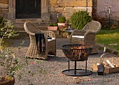 Two wicker armchairs and fire basket on Mediterranean terrace