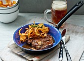 Entrecote steak with potato crisps and a glass of dark beer