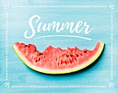 Angebissene Melonenspalte auf blauem Holzhintergrund mit Schriftzug 'Summer'