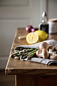 Green asparagus and brown mushrooms on a kitchen towel