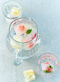 Mineral water with summer fruit ice cubes in a jug