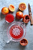 Making blood orange juice with a hand citrus squeezer