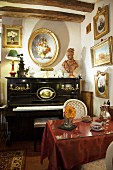 Antique gilt-framed painting above piano and table