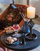 Lit candle and biscuits on side table