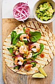 Shrimp wraps with guacamole and red onions