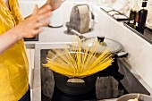 Woman in kitchen preparing spaghetti