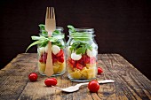 Insalata Calabrese mit Nudeln, Tomaten, Mozzarella, Rucola und Basilikum in Gläsern
