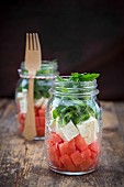 Salat mit Wassermelone, Rucola und Feta in Gläsern