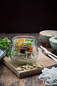 Asian rice noodle soup with vegetables and tofu in jar