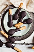 Löffelförmige Kekse mit Schokoladenglasur auf Teller