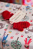 Small red knitted mittens used as gift tags