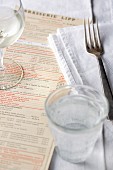 A table setting, water and a menu in a restaurant