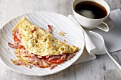 A cheese and ham omelette with tomato