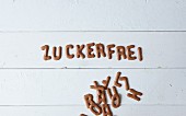 The German word 'zuckerfrei' (sugar-free) spelled out in chocolate letter-shaped biscuits