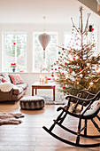 Rocking chair in front of decorated Christmas tree in living room