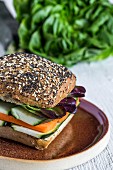 Veganer Burger mit frischem Gemüse auf rustikalem Hintergrund