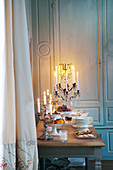 Buffet on candlelit table in front of panelled wall
