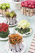 Small cake-shaped arrangements of natural materials as autumnal table decorations