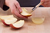 Apfelschnitze mit Zitronensaft bepinseln - verhindert das braun werden